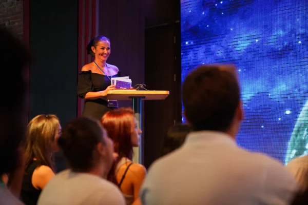 speaker talking on stage and showing presentation to audience