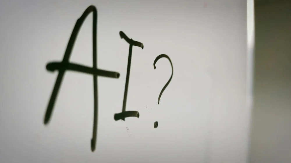 AI stock image - photo of AI written on whiteboard with question mark after it